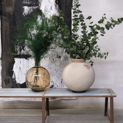 Lang solid bænk i rå metal og træ.