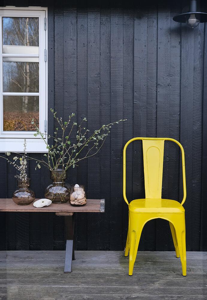 Lang bænk i genanvendt træ med rå jernkanter.