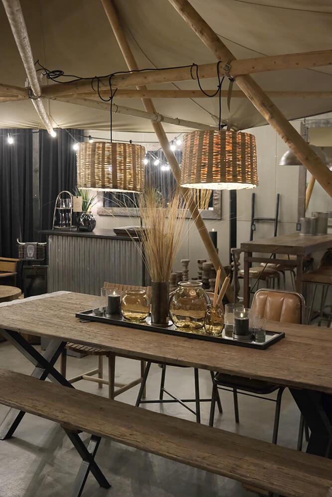 Lang bænk i genanvendt træ med rå jernkanter.